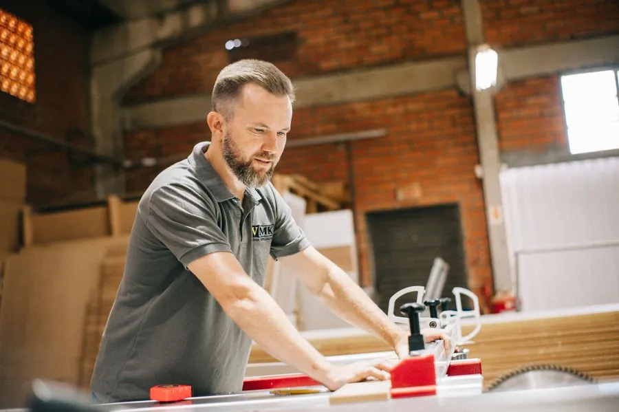 A carpenter at a workbench in a bright workshop