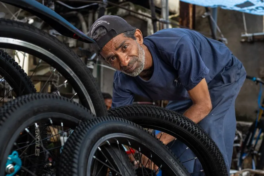 A mechanic working on a bicycle wheel