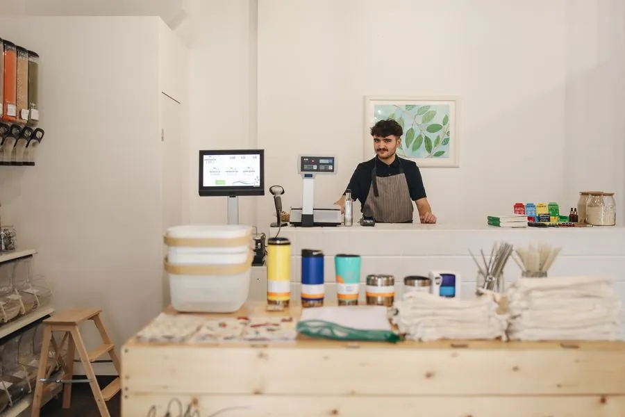 A shop owner arranging goods on a counter