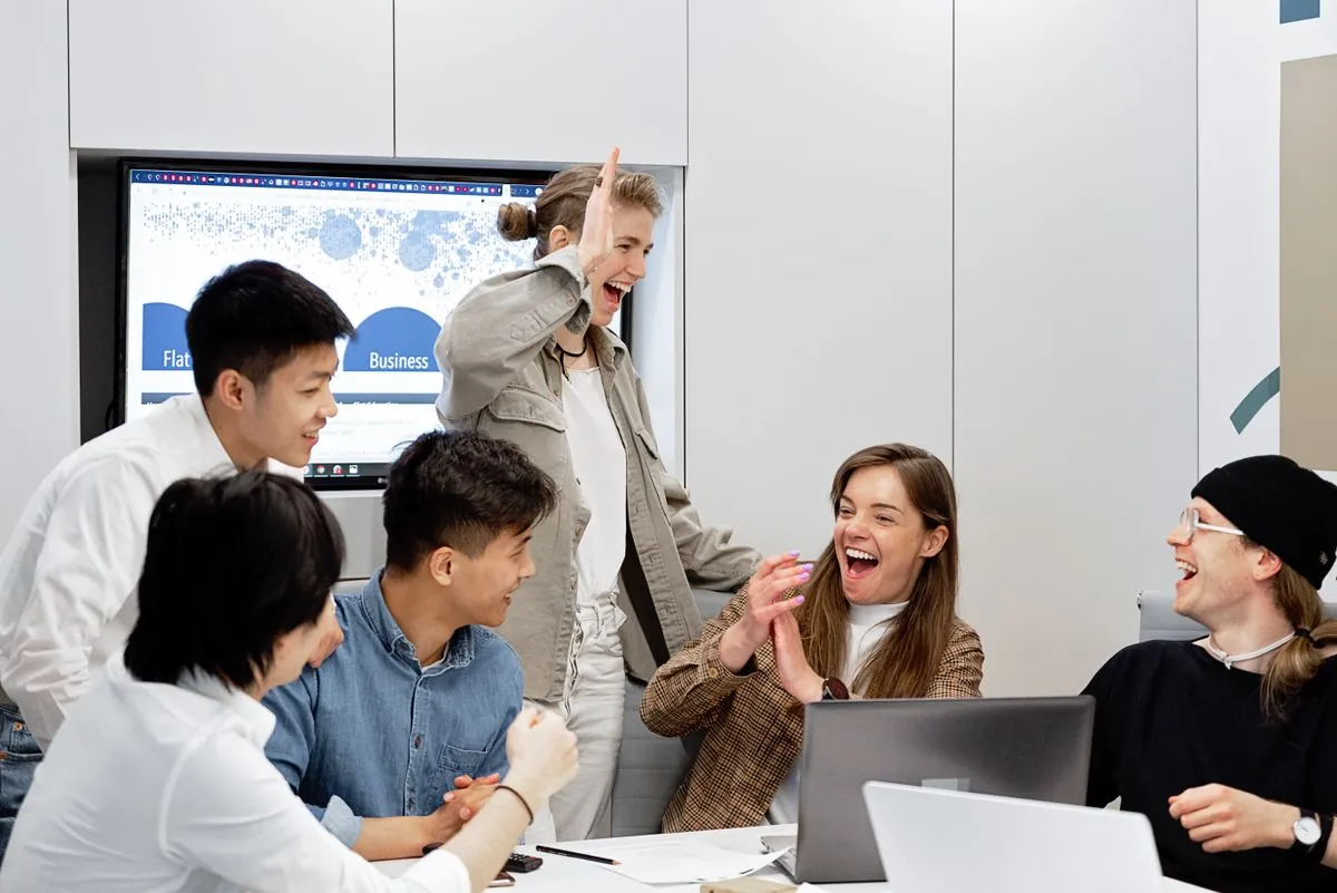 A team gathered around a laptop in an office